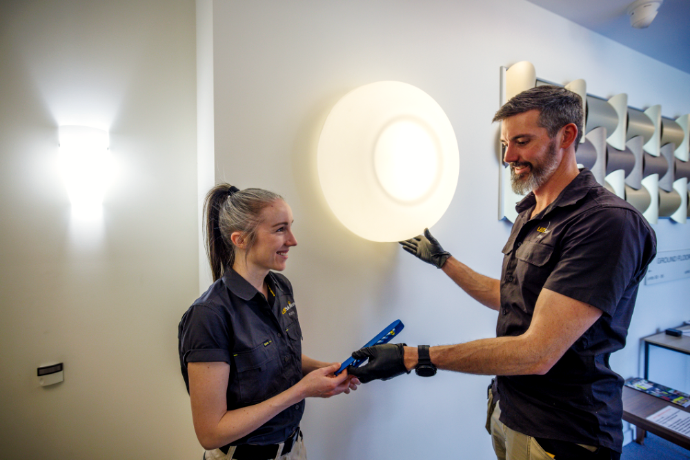 LED Solutions team members fitting a wall light together