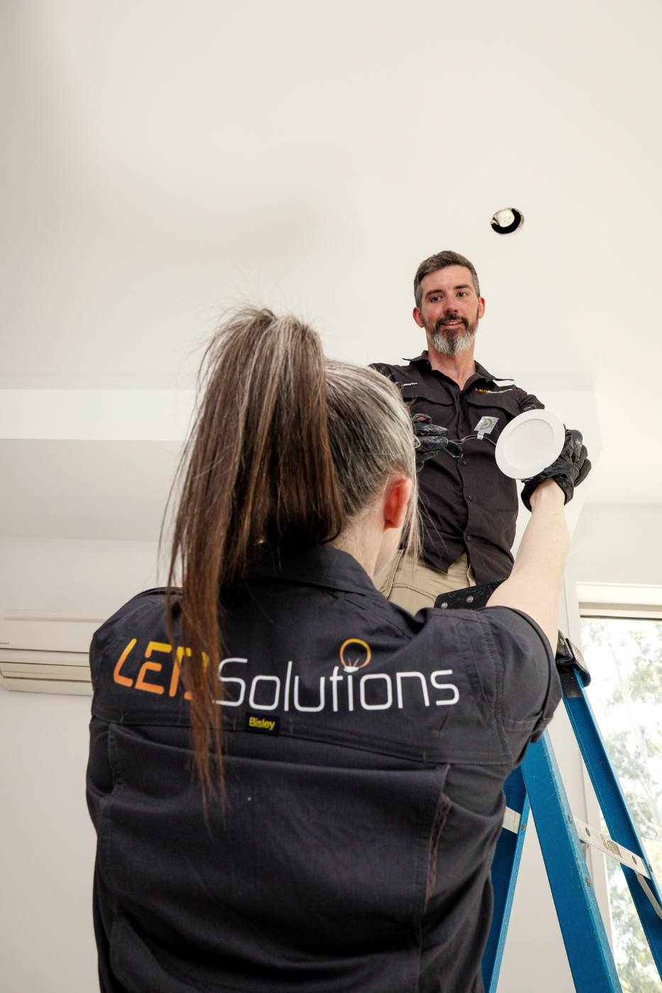 Two LED Solutions electricians fitting a downlight together